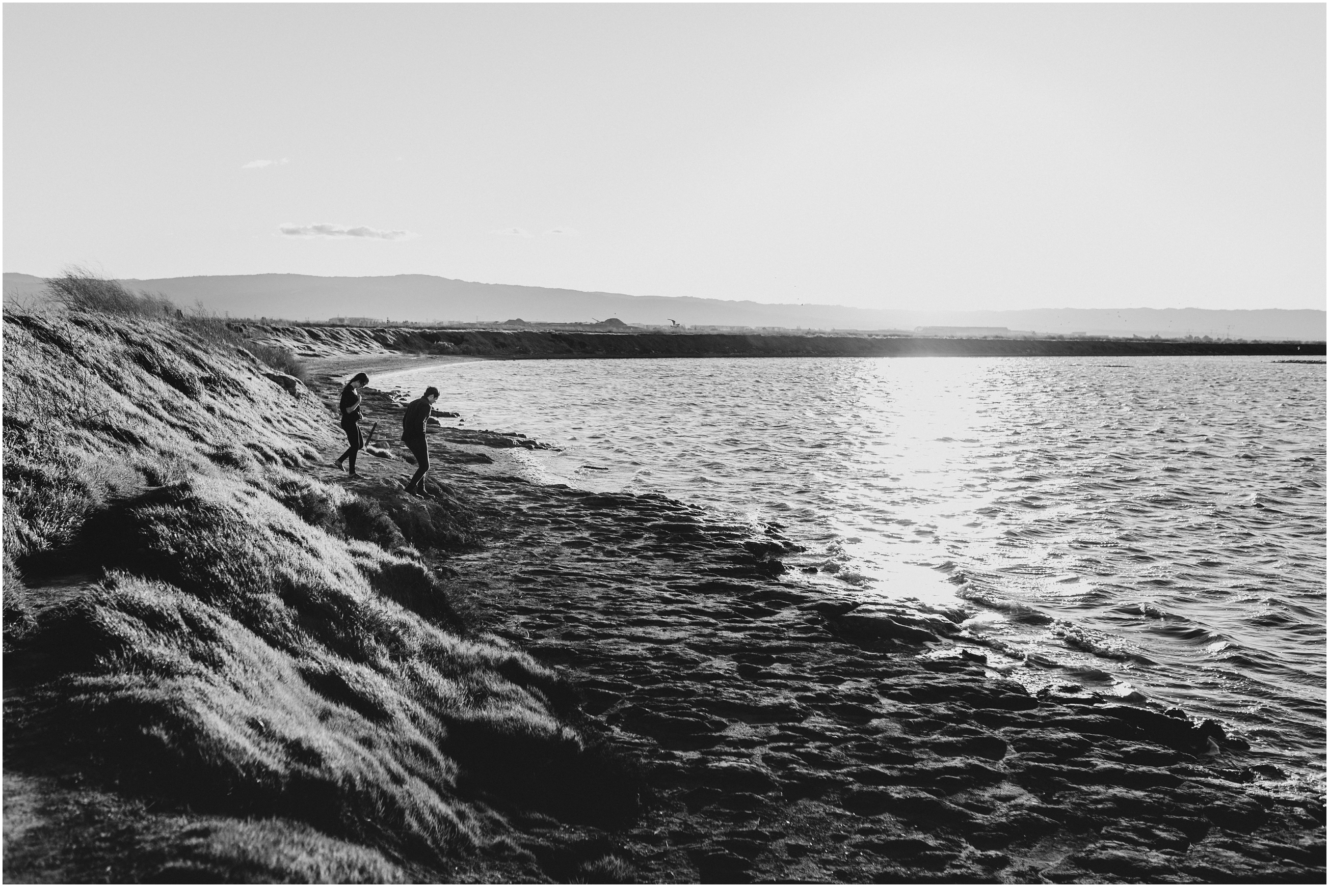wide landscape black and white of beach with couple walking in distance in bay area california