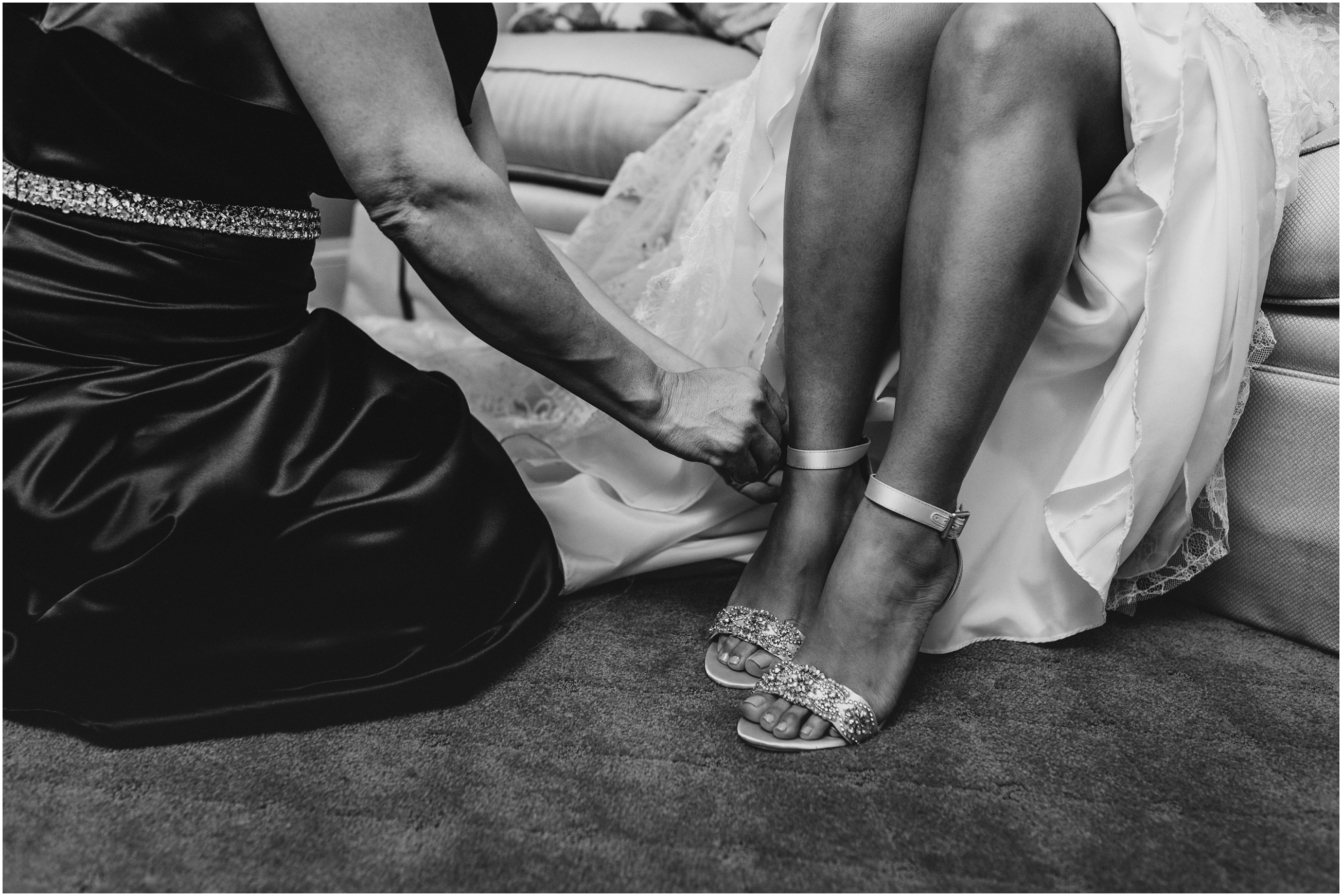 bride's mother helping bride put on heels