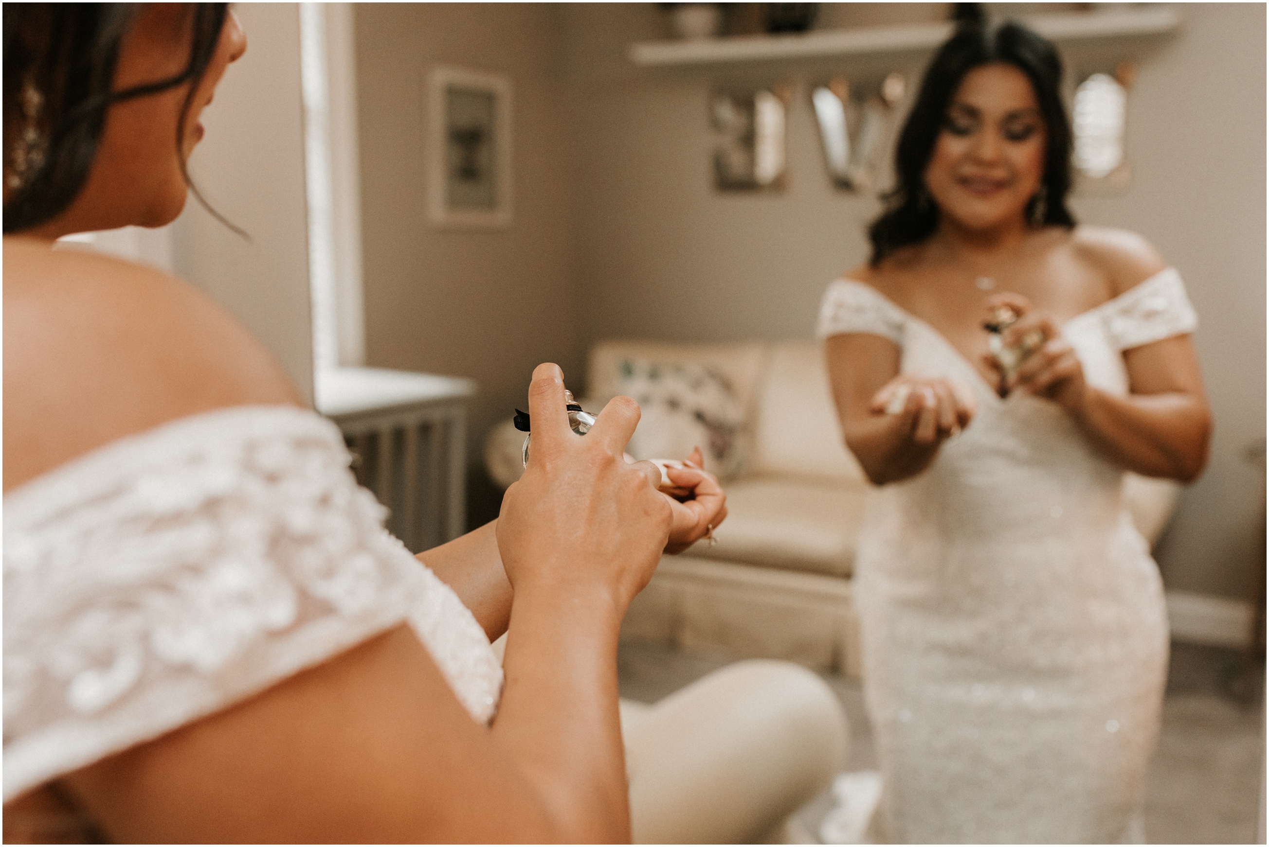 bride putting perfume on in mirror