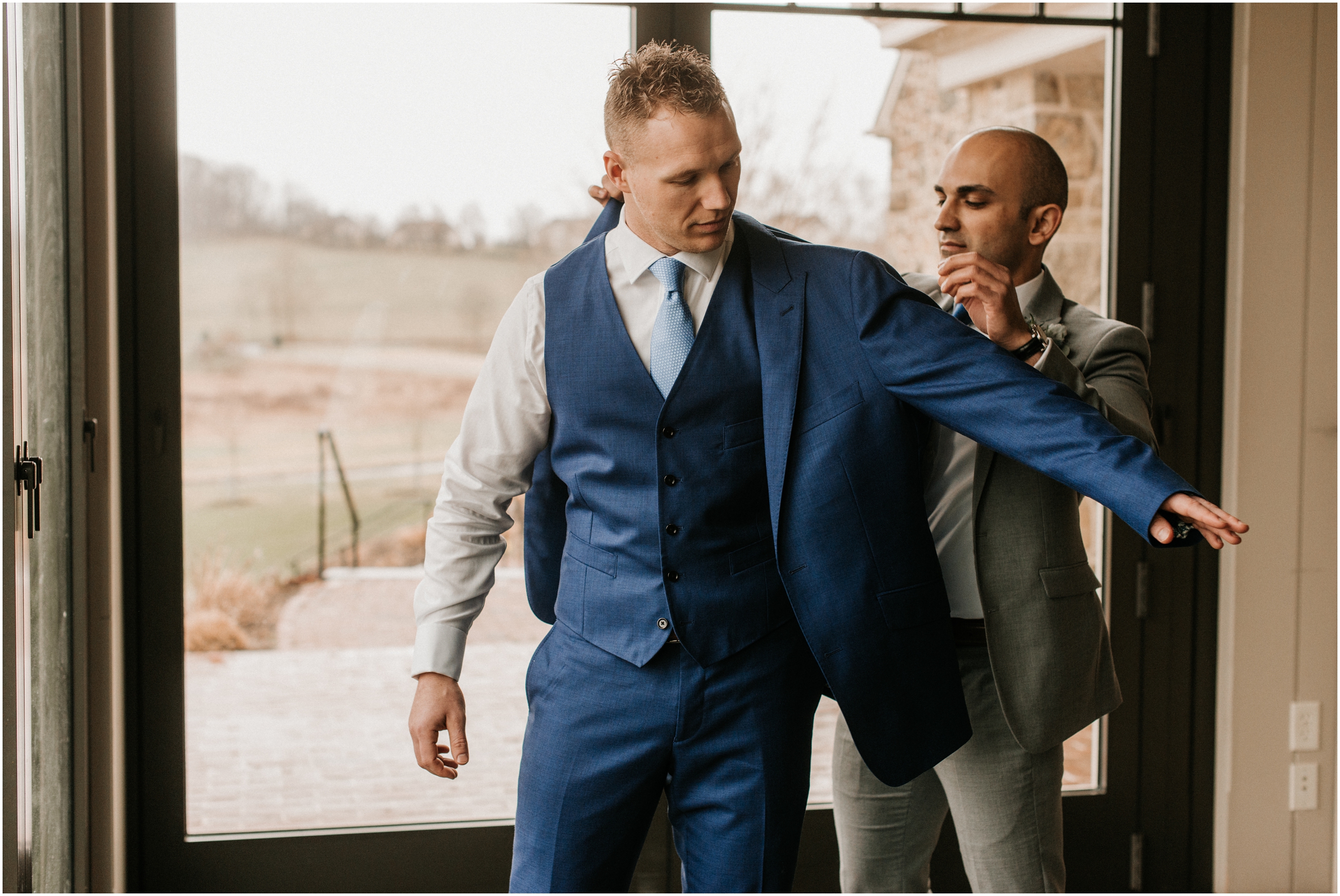 best man putting groom's suit jacket on