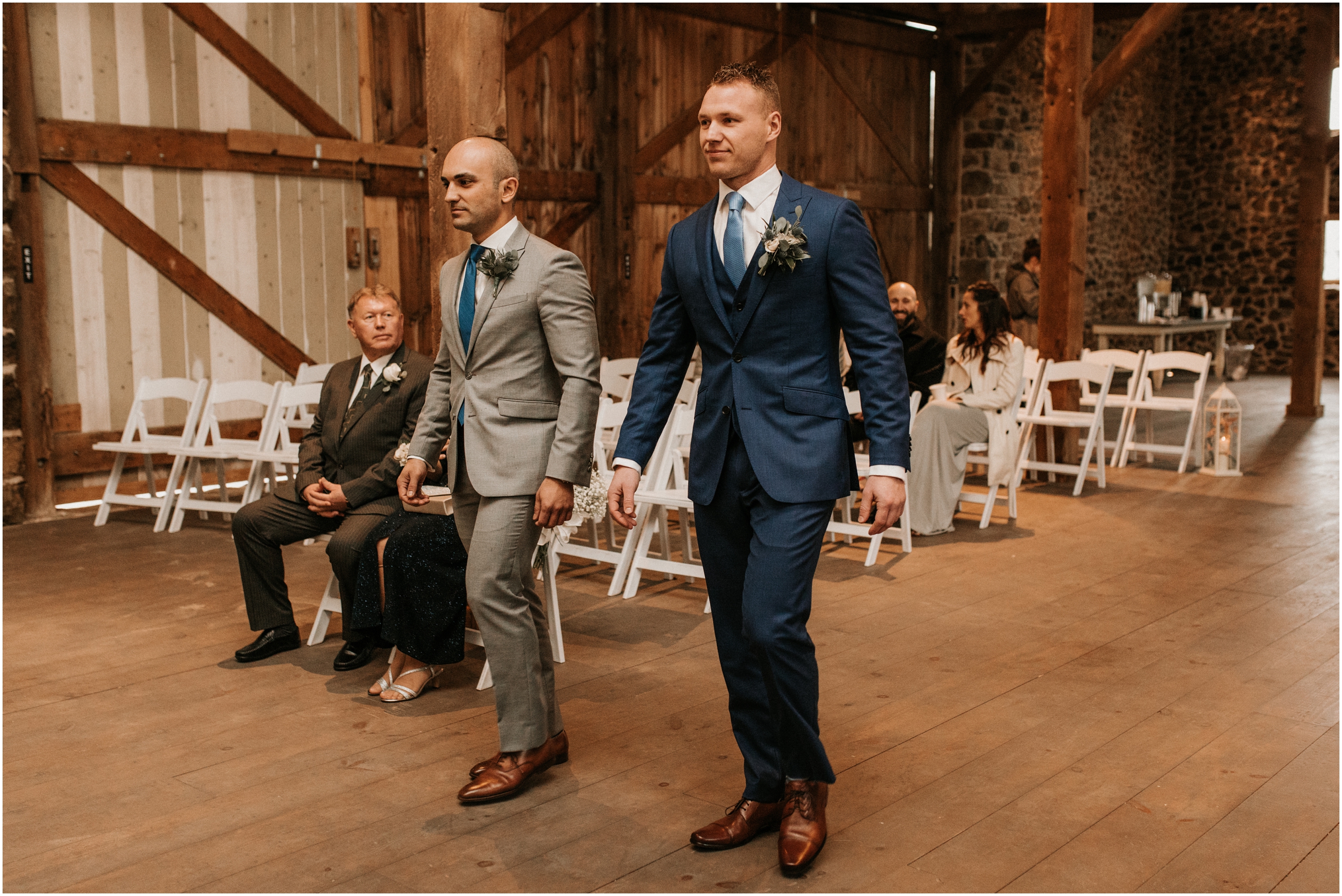 groom walking down aisle in barn