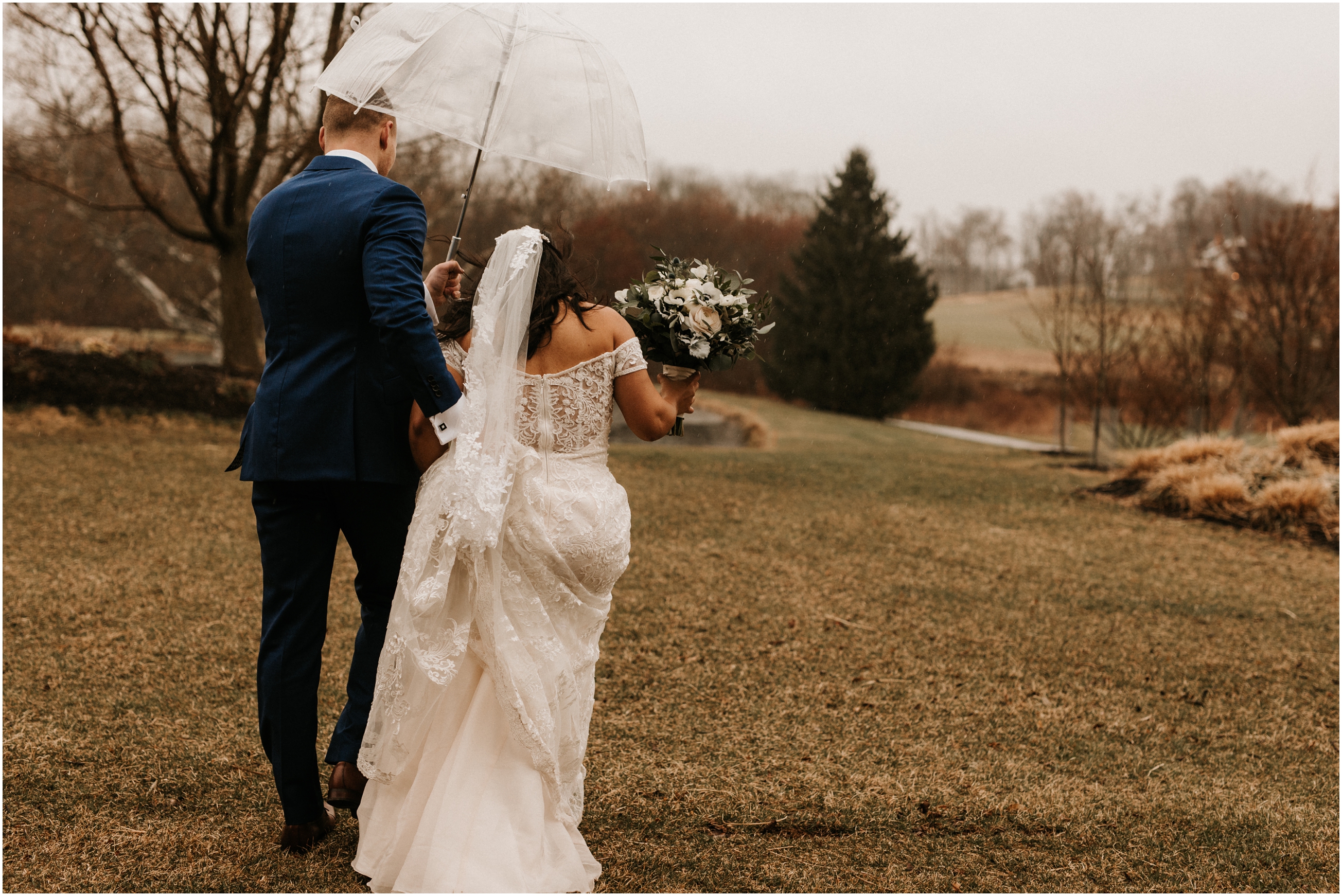 bride and groom walking outside with umbrella