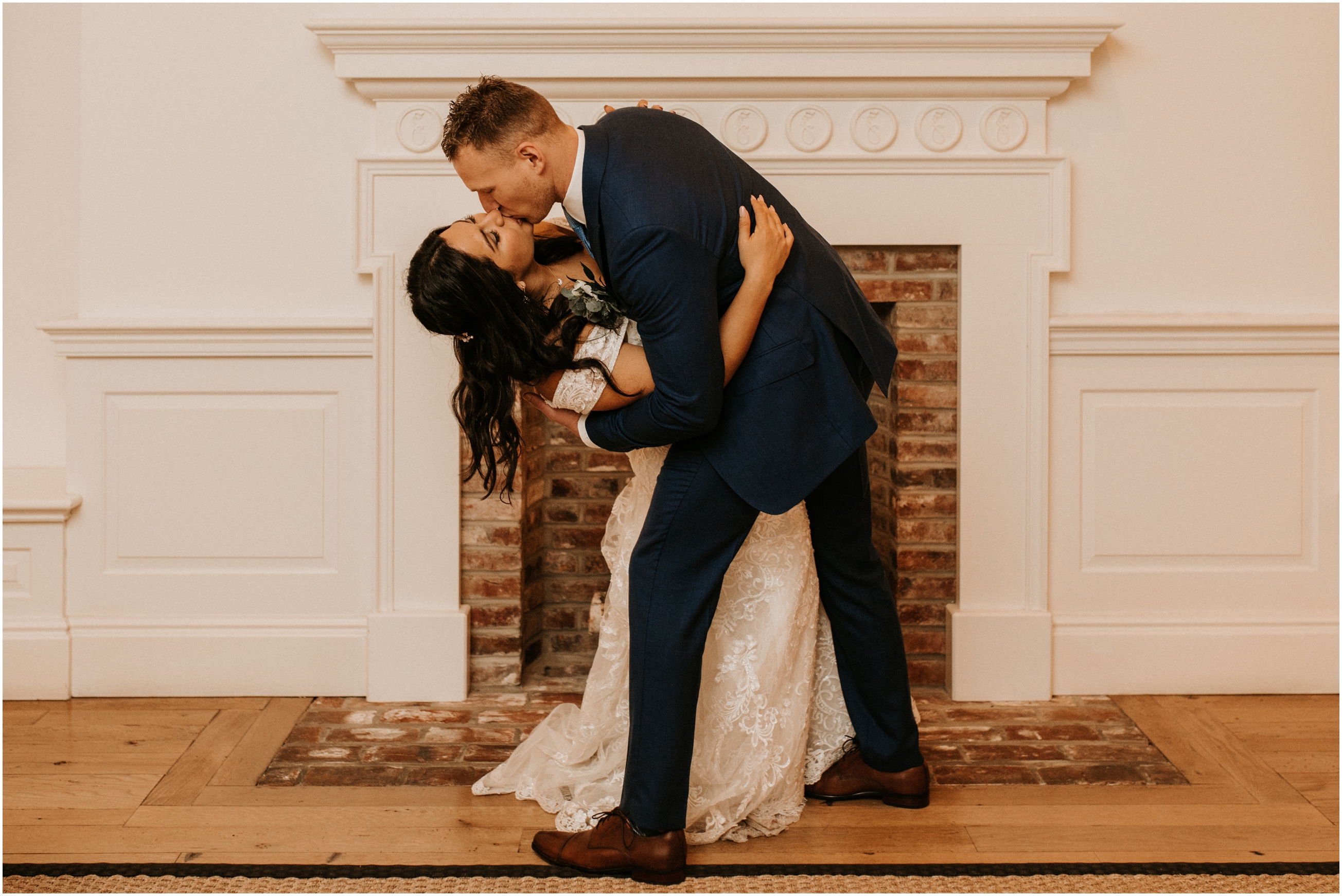 bride and groom kissing by fireplace
