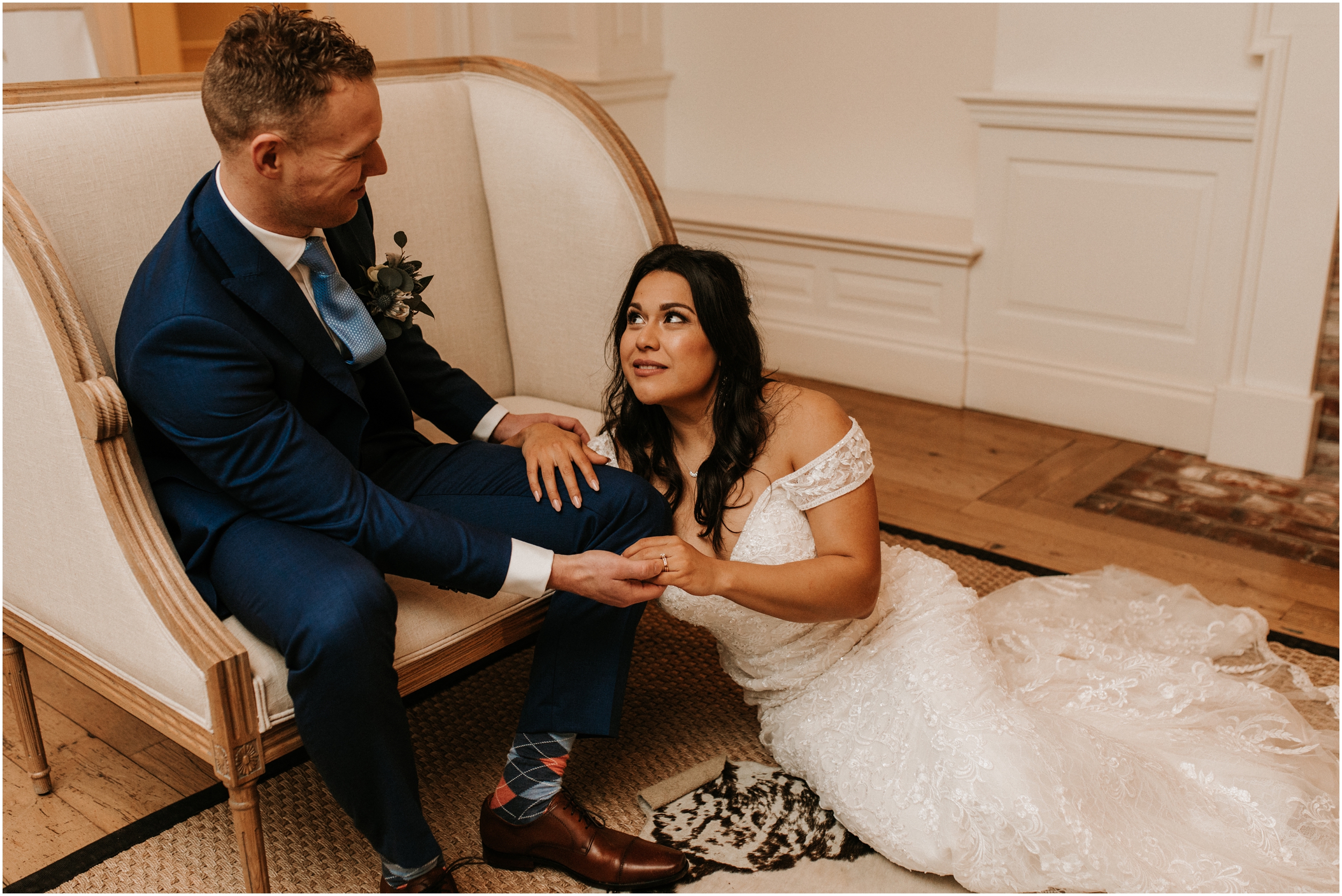 bride sitting down on ground and leaning on groom's knee