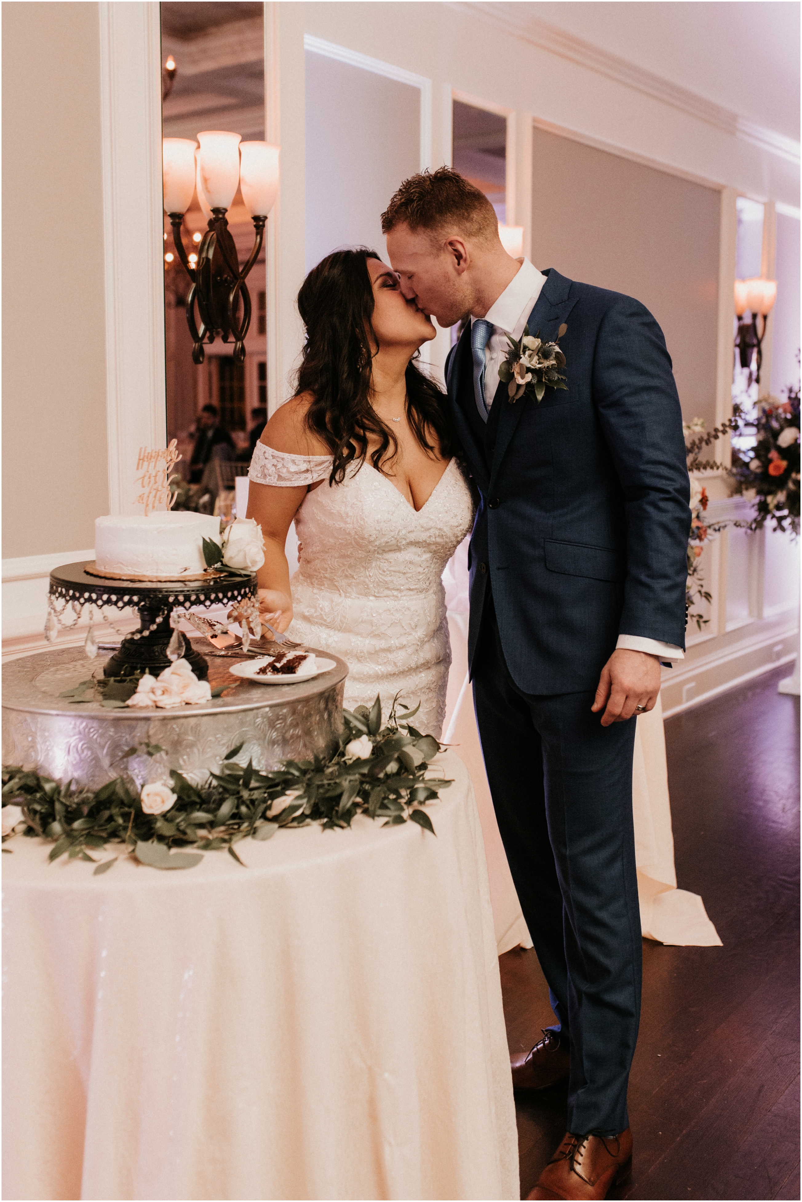 bride and groom cutting cake kiss