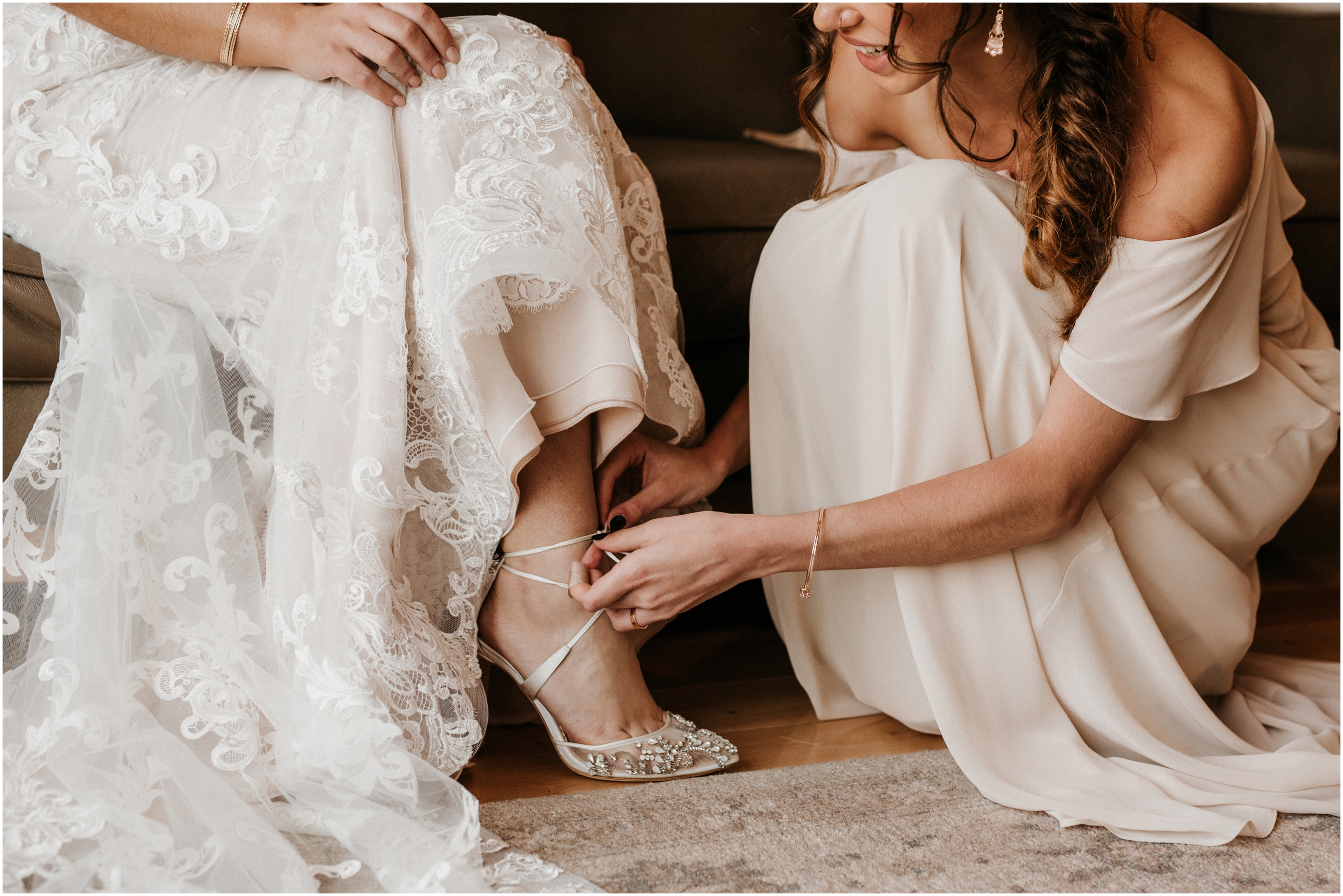 bridesmaid putting bride's heels on