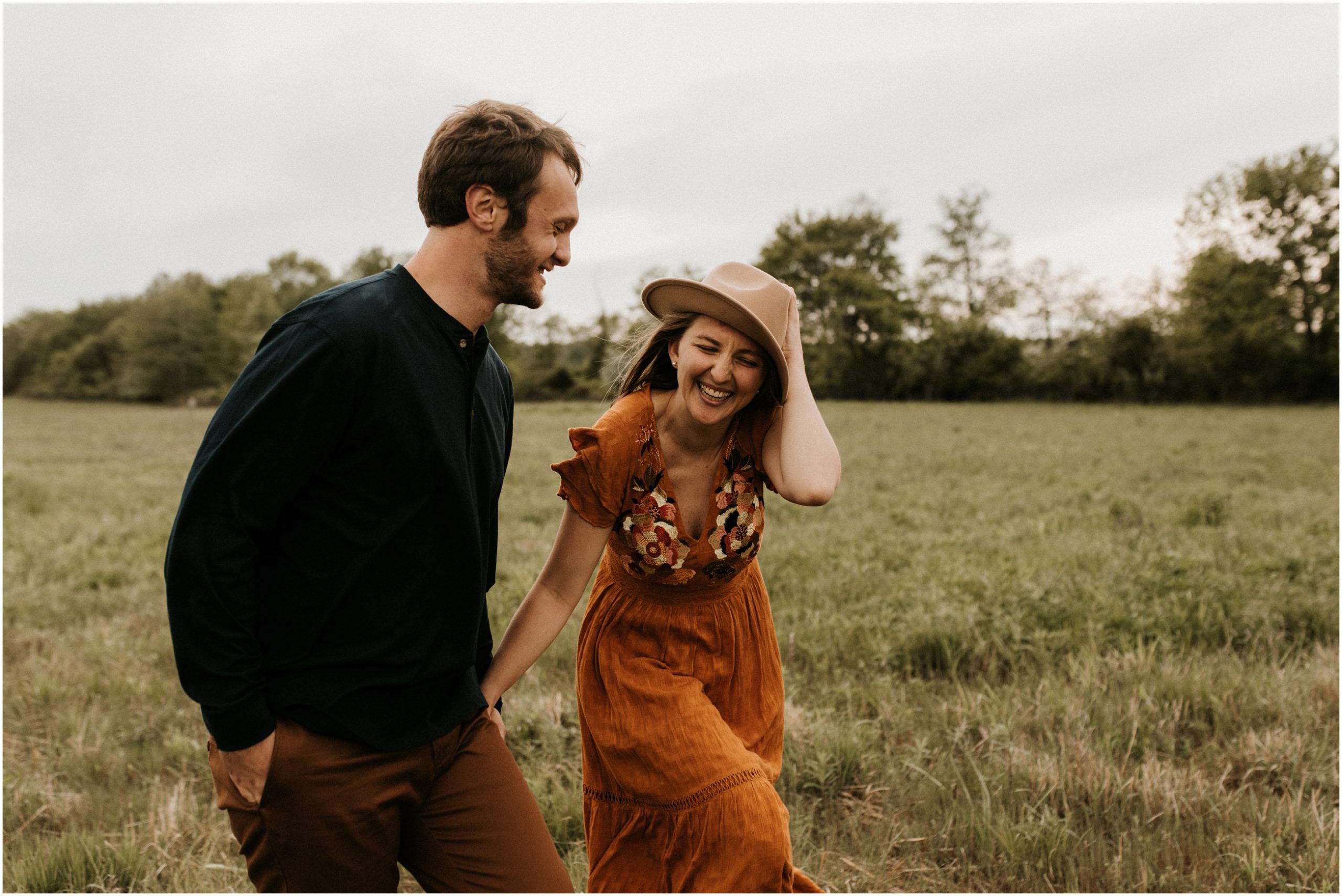 couple walking and laughing in open field