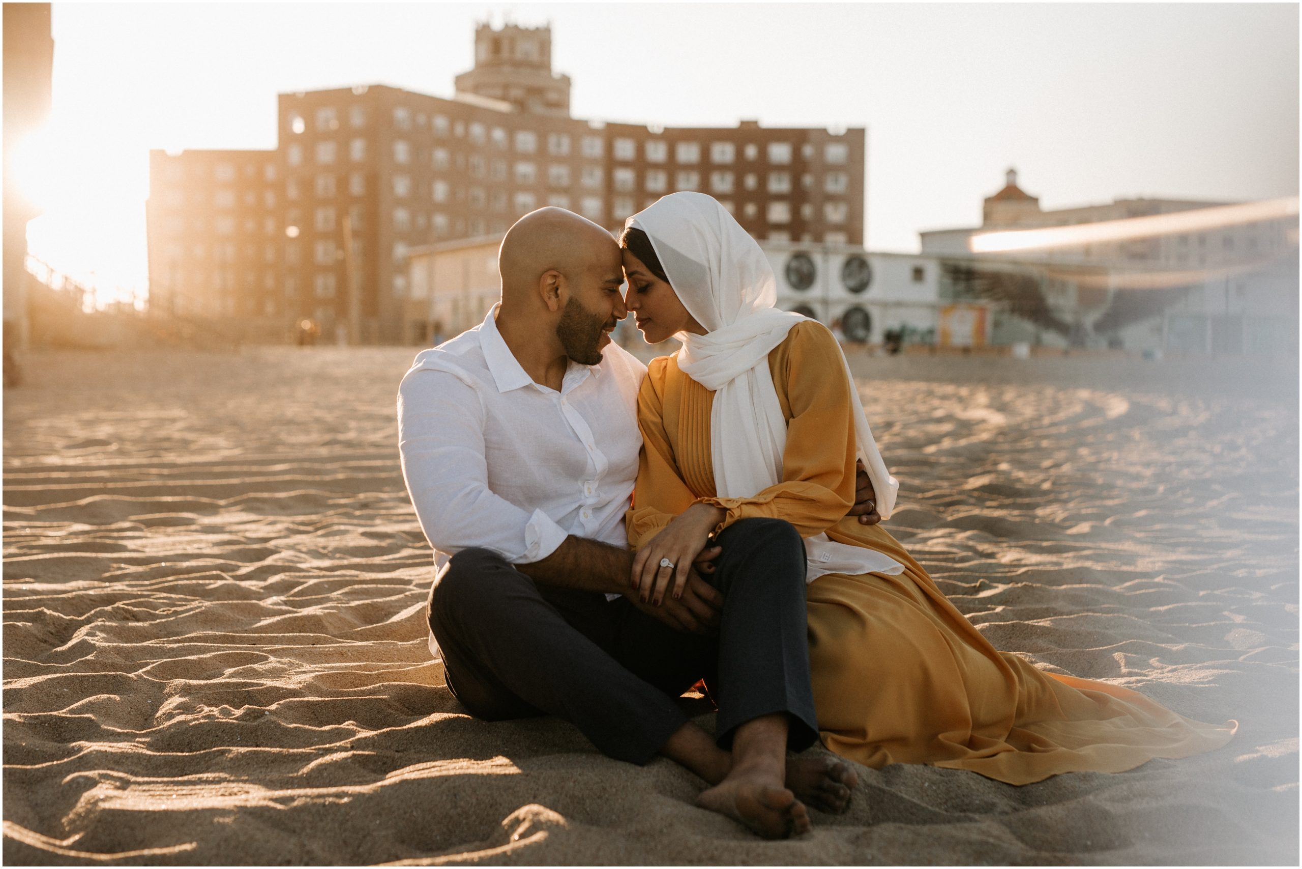 couple sitting on beach at sunset in new jersey