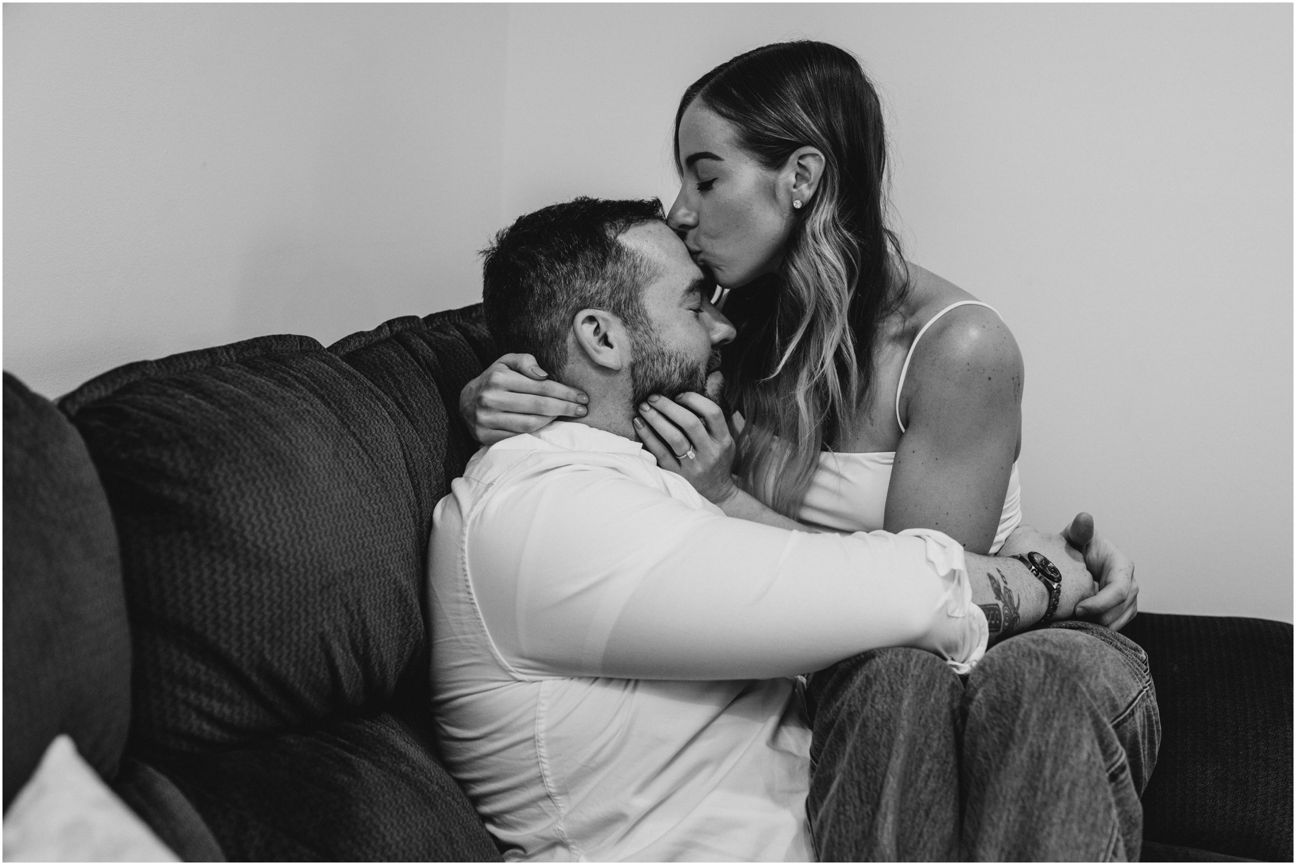 black and white image of couple kissing on couch