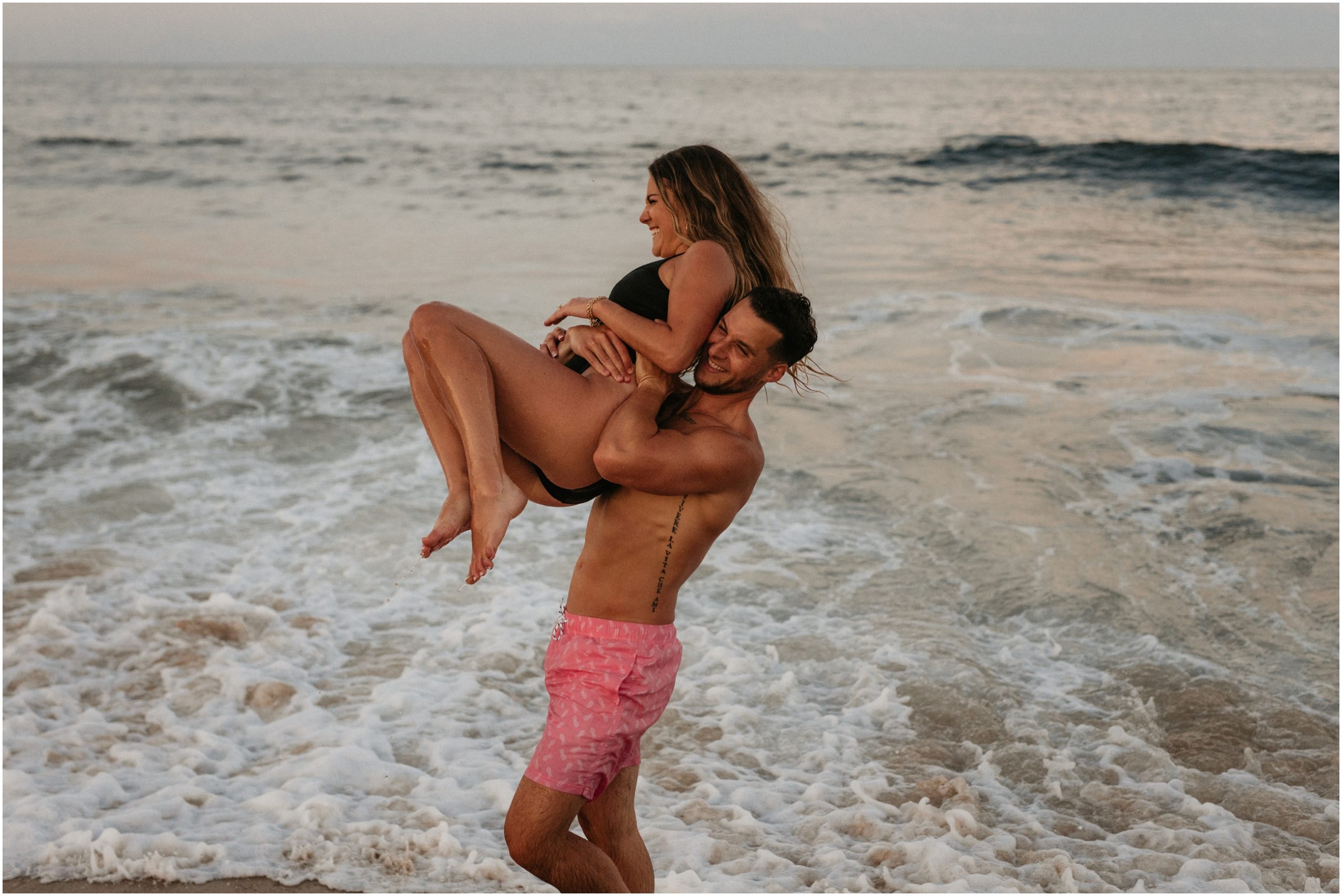 man lifting woman in ocean in new jersey