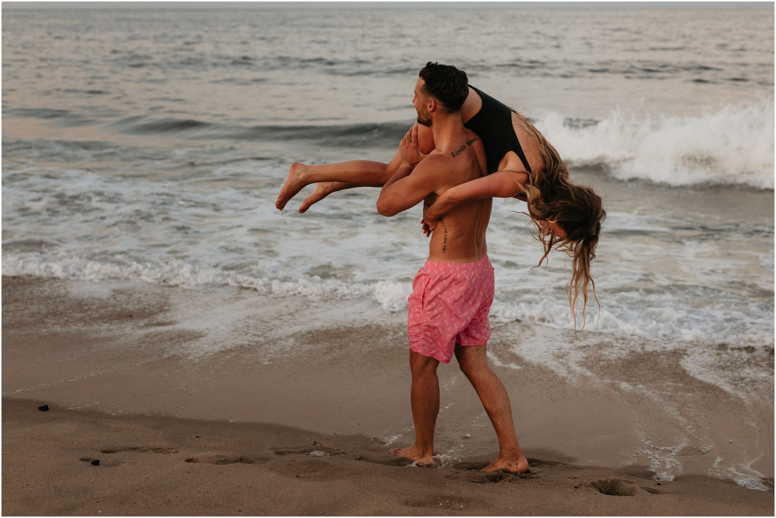 man lifting woman in ocean in new jersey