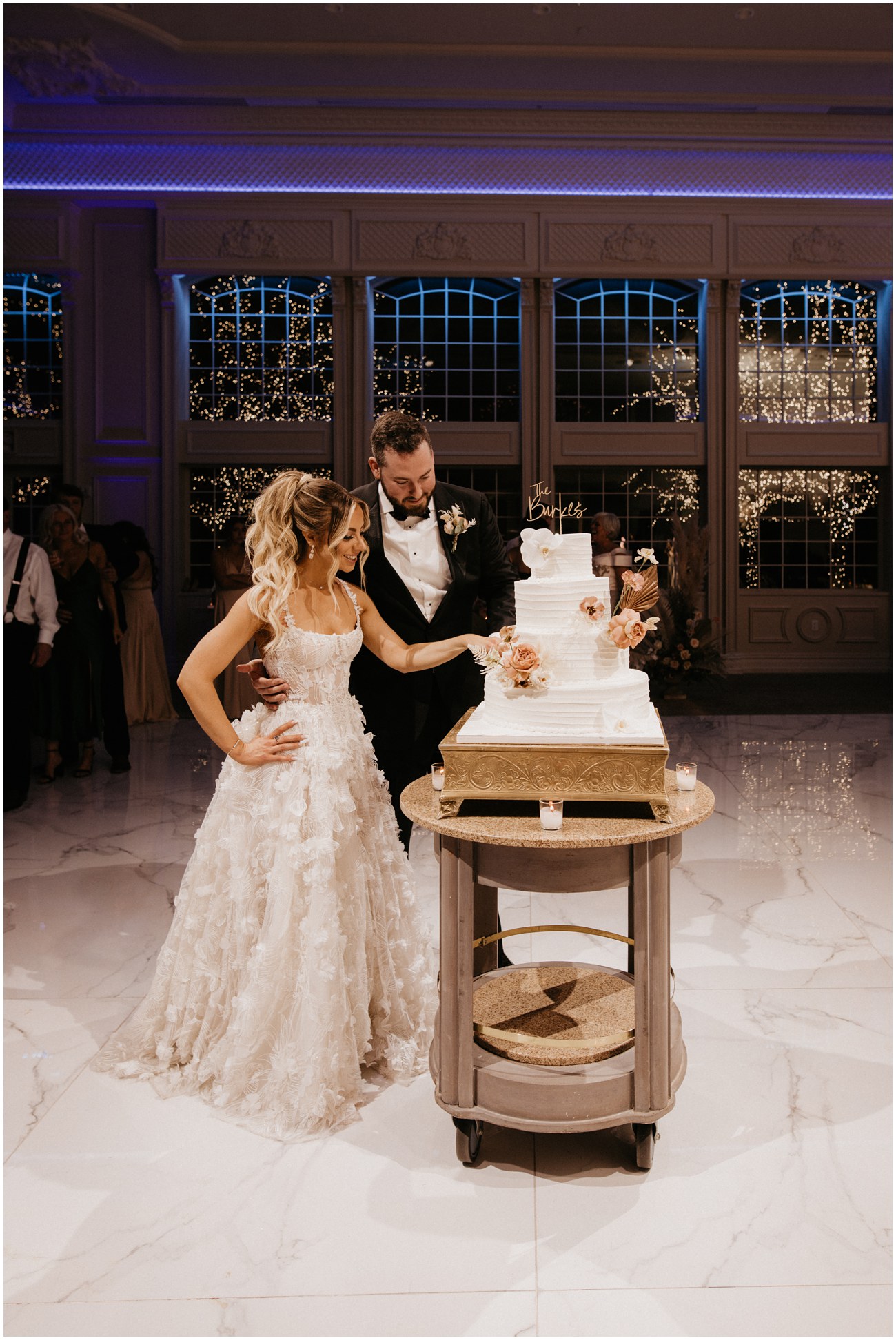 bride and groom cut cake during wedding reception at florentine gardens in new jersey
