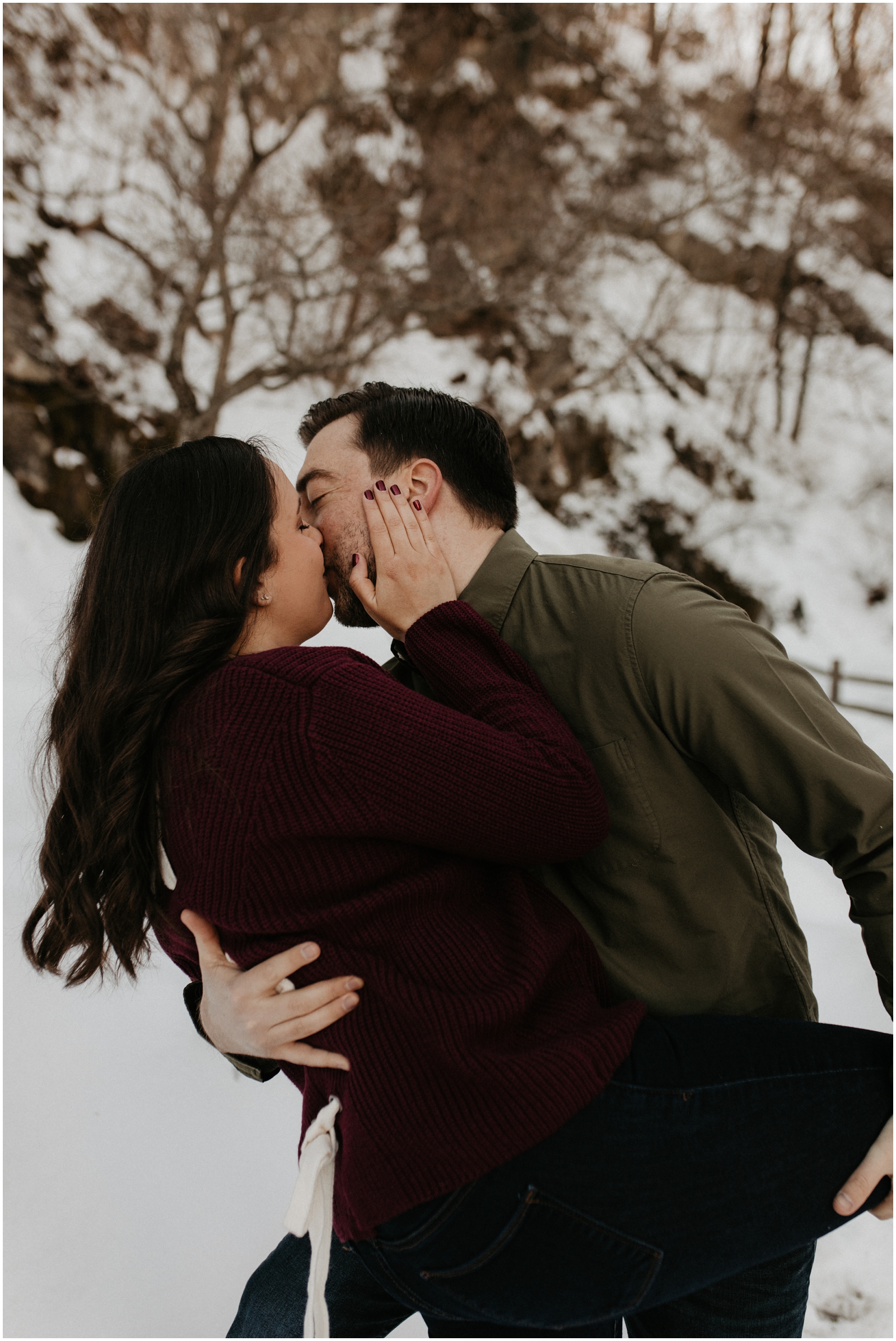 couple kissing in snow at red mill museum in clinton, nj