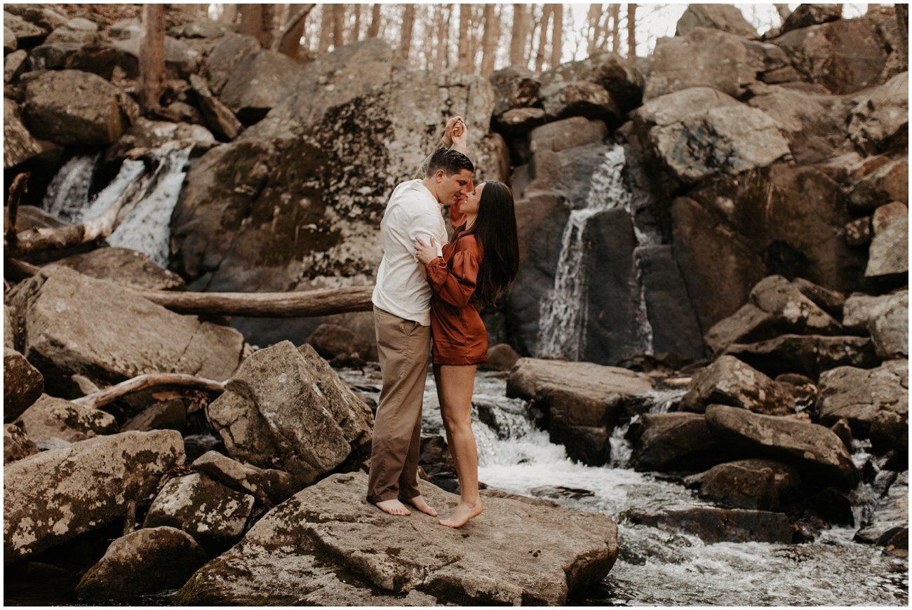 couple kissing near waterfall