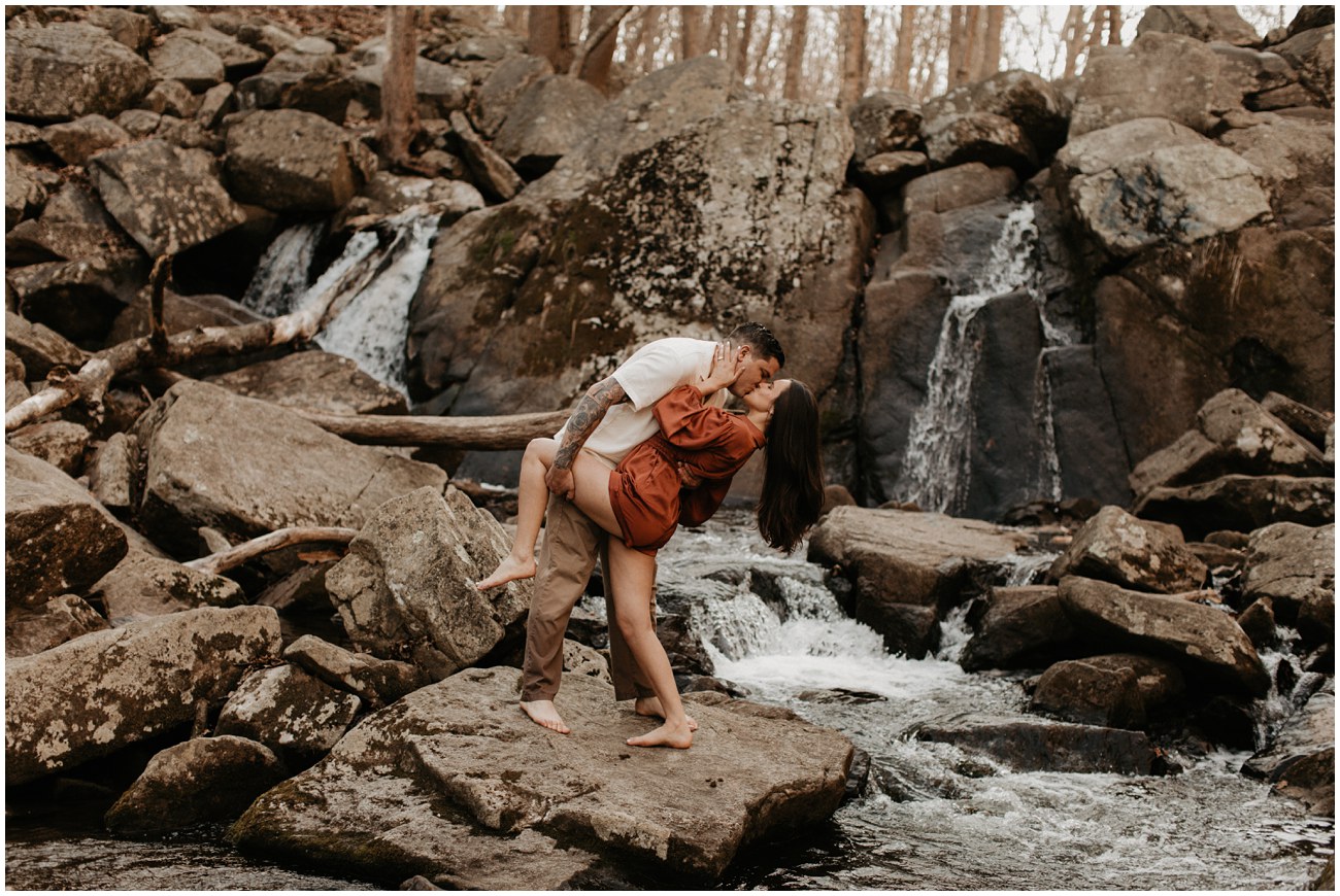 couple kissing in waterfall at engagement session in hacklebarney state park in new jersey
