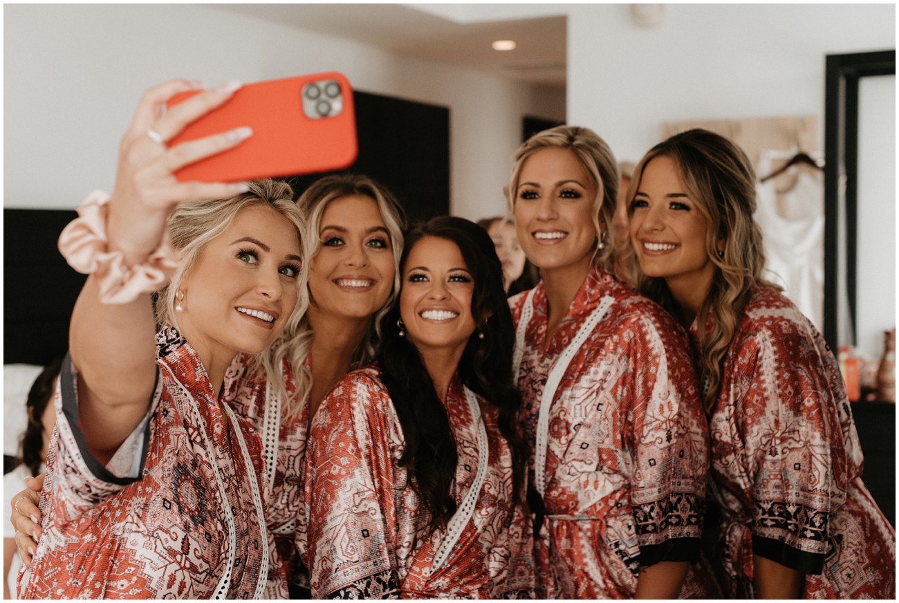 bridesmaids taking selfie in matching robes