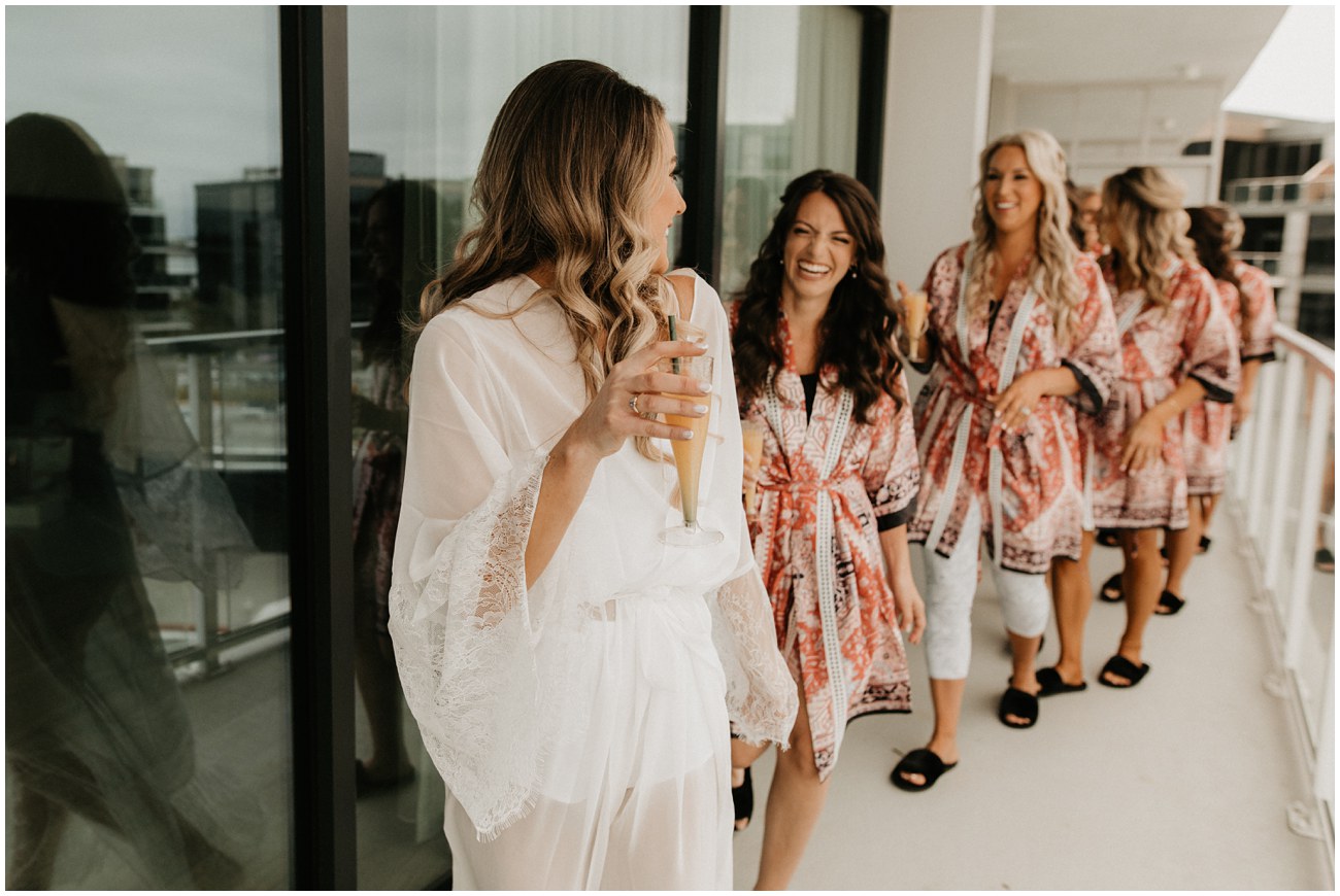 bride and bridesmaids in matching robes with mimosas