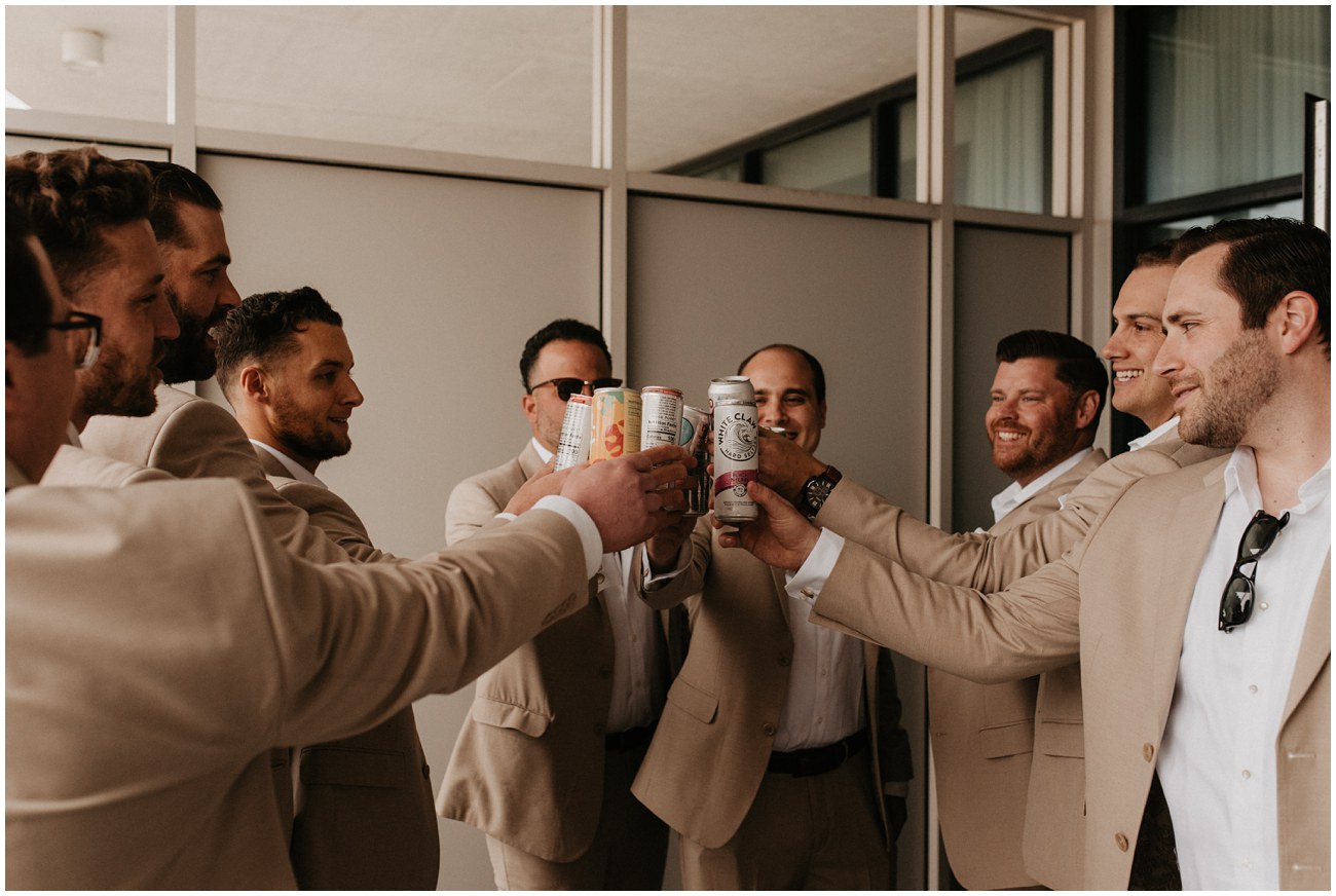 groom and groomsmen cheering drinks