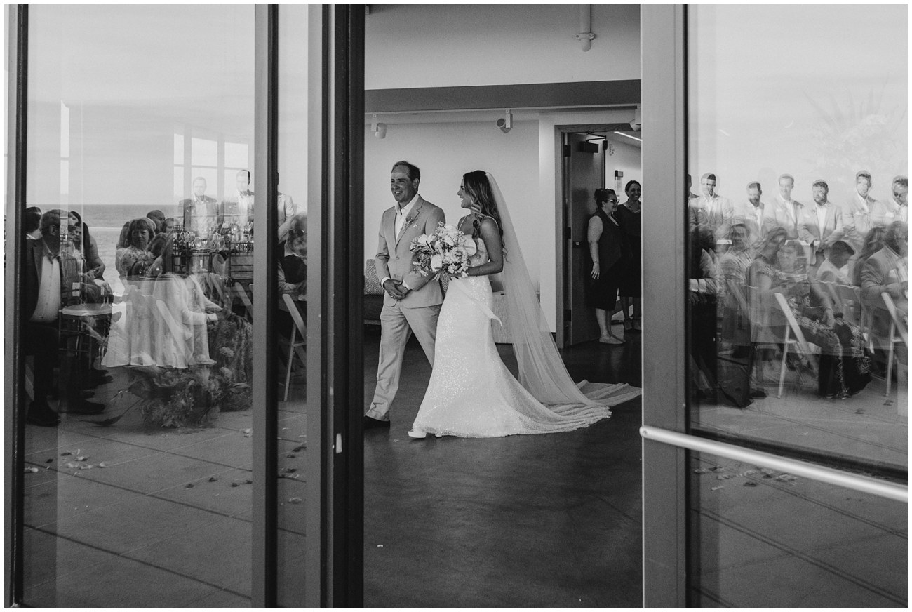 bride and father walking down aisle during ceremony at wave resort in new jersey