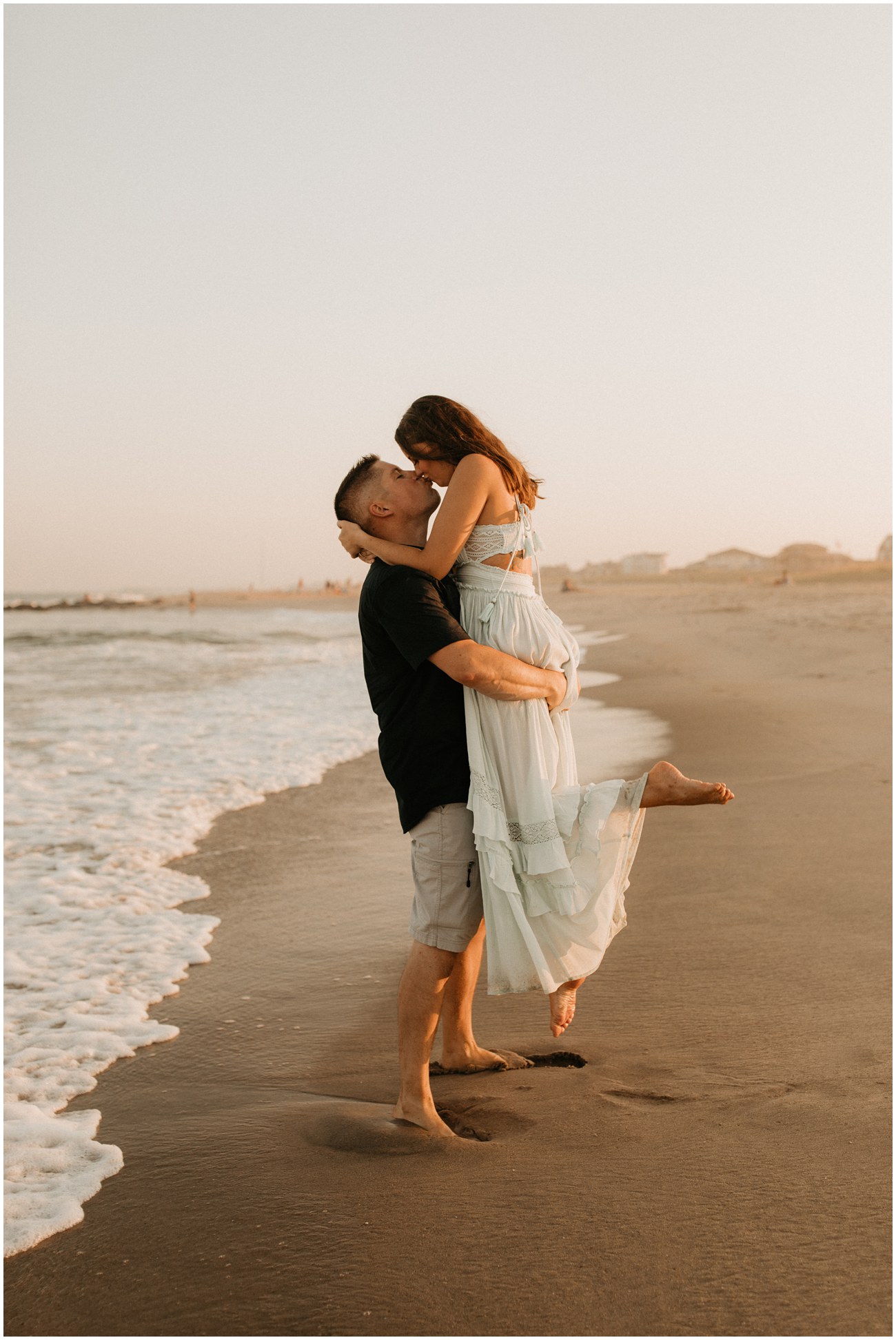 Man lifts woman for a kiss on the beach