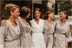 bridesmaids in robes on porch laughing