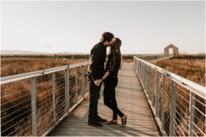 couple kissing on bridge at sunset in bay area california