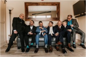 groom and groomsmen laughing on couch