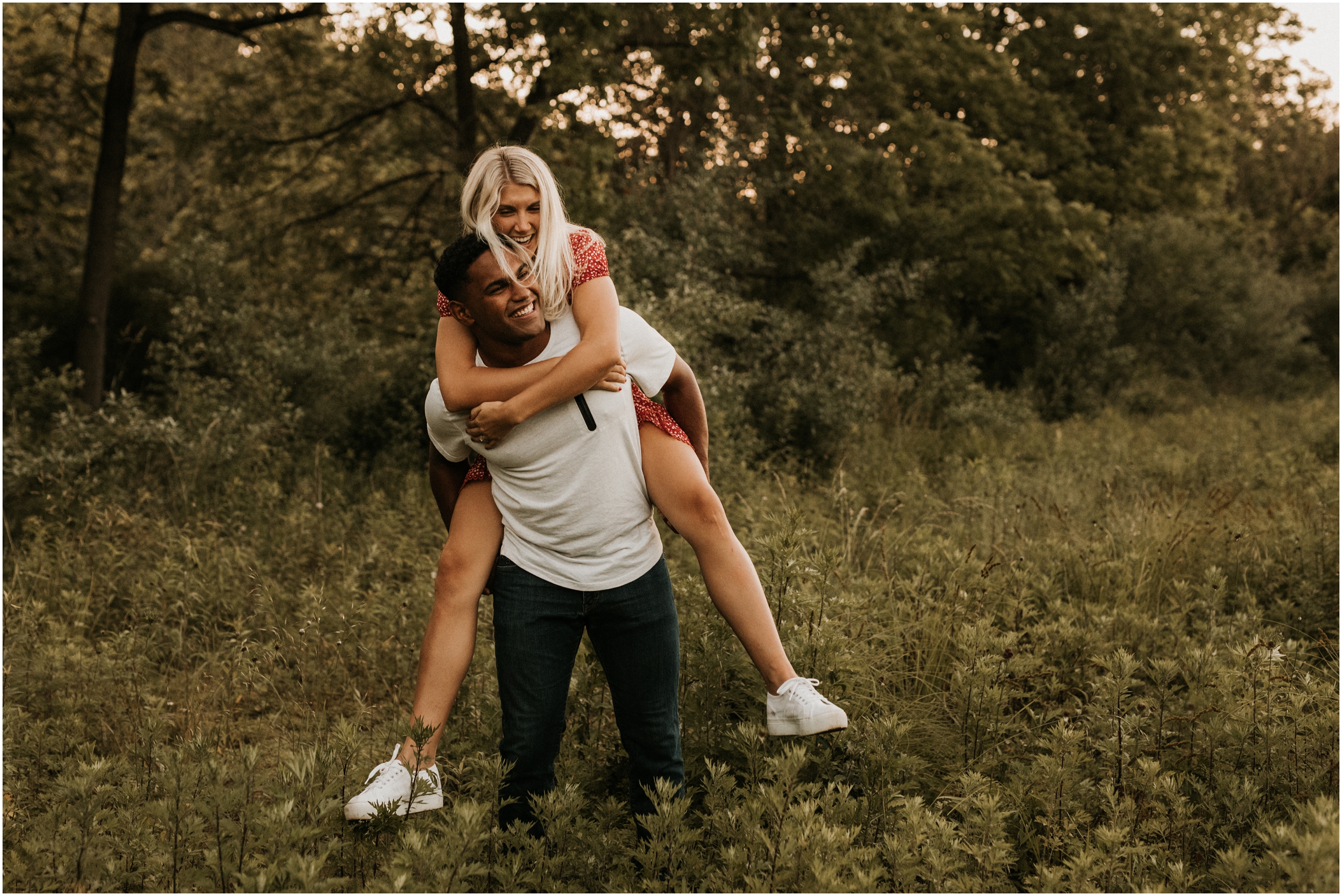 couple in field doing a piggy back ride