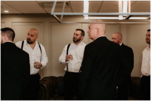 groom drinking cocktail with groomsmen