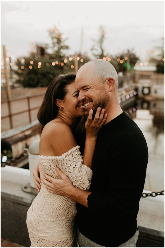 Couple smiles and they nestle into each other for Philadelphia engagement session