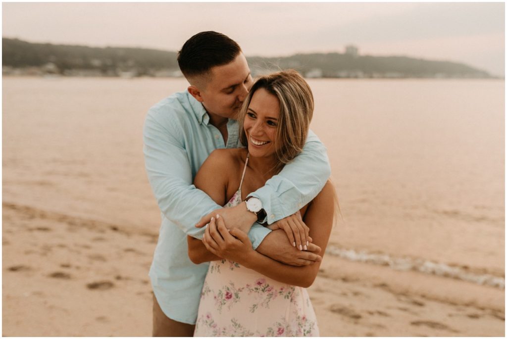 Couple embraces on the shoreline at Sandy Hook beach