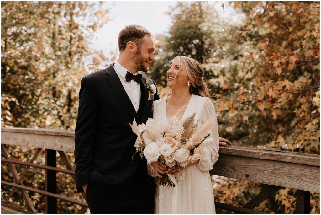 Bride and groom smiles together at fall Boathouse at Mercer Lake wedding